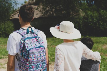 Family traveling and walking through picturesque park back to the camera. Travel concept, horizontal and color image.の写真素材