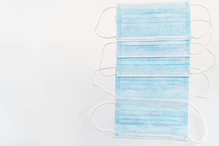 Blue medical face mask on white background, virus protection. Isolated, top view and with copy space...