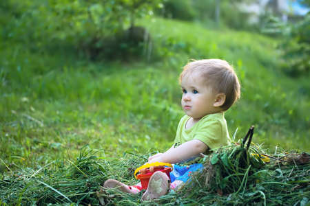 Country lifestyle - one year old baby sitting on a haystackの写真素材