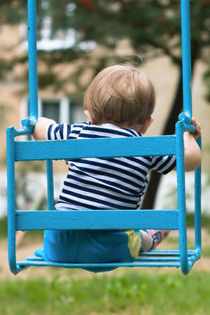 One year old baby on a swingの写真素材