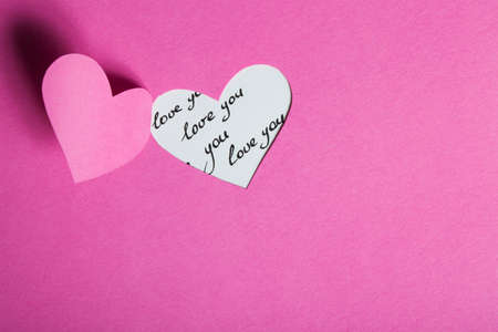 Heart Half-Cut From Pink Paper with Handwritten Backgtoundの写真素材