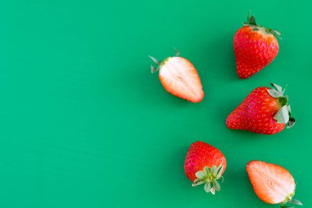 Strawberries on green background. Flat lay, top view.