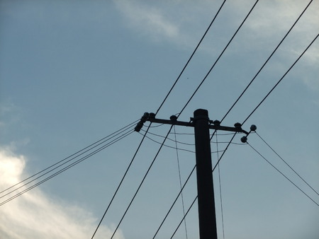 Pole and wire under the blue skyの写真素材