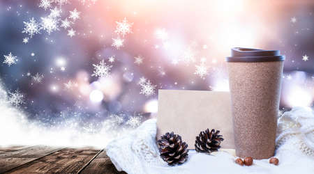 Hot coffee on a wooden table against the background of a winter landscape in a winter snowy forest. Coffee on the background of winter mountains. Snowflakes, frost.の写真素材