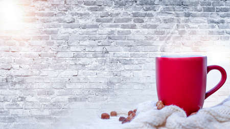 Red cup with coffee, tea on a snowy background, winter forest. A red cup against the background of a...