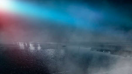 Dark street reflection on wet asphalt, fog, night city. Rays of neon light in the dark, neon light, smoke. Empty background scene. Abstract dark background.の写真素材