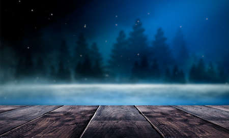 Dark abstract winter forest background. Wooden floor, snow, fog. Dark night background in the forest...