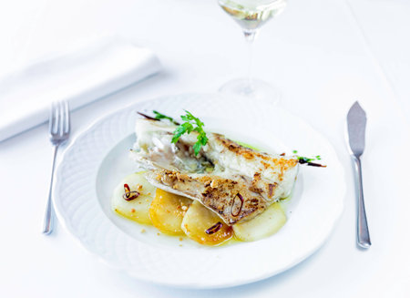 Roasted hake neck on white plate