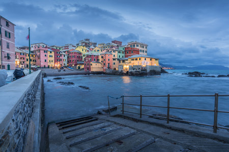 Beautiful panorama of Boccadasse, Genova in Italy at blue hour with rough seaの写真素材
