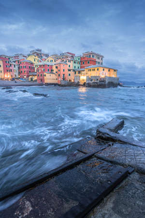 Beautiful panorama of Boccadasse, Genova in Italy at blue hour with rough seaの写真素材