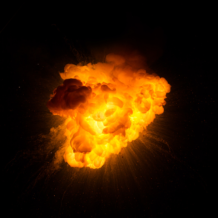 Realistic fiery explosion with sparks over a black backgroundの写真素材