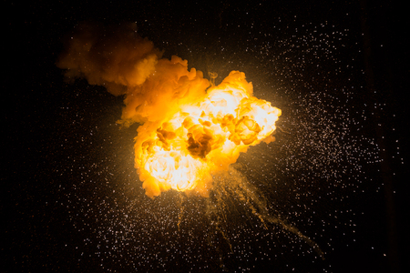 Realistic fiery explosion with sparks over a black backgroundの写真素材