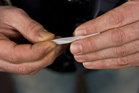 a closeup of hands rolling tobacco. の写真素材