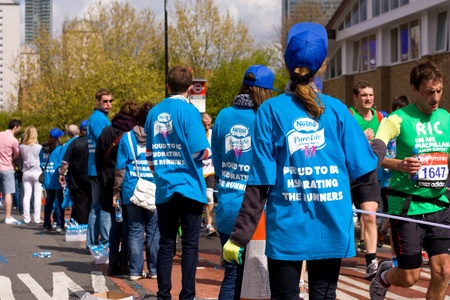 LONDON - APRIL 22: Volunteer giving water to runners at the London marathon on April 22, 2012 in...