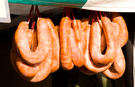 hanging sausages at a farmers market.の写真素材