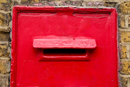 a traditional red post box in a wall. の写真素材