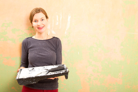 woman holding a paint tray and roller.の写真素材