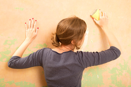 young woman sanding wallの写真素材