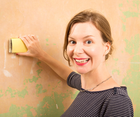 young woman sanding wallの写真素材