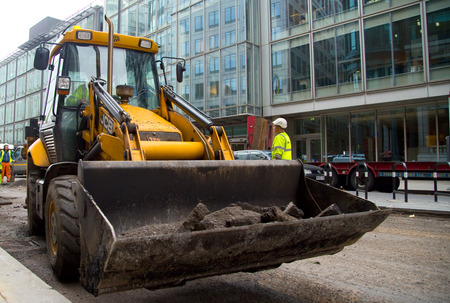 LONDON - OCTOBER 18TH: Unidentified workman operates a JCB on October 18th, 2014 in London, England,...