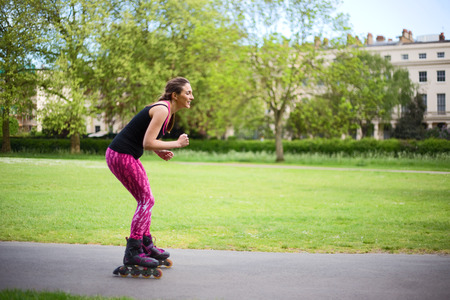 young woman roller skates in the parkの写真素材