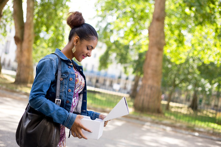 young woman looking in a box at her new shoesの写真素材
