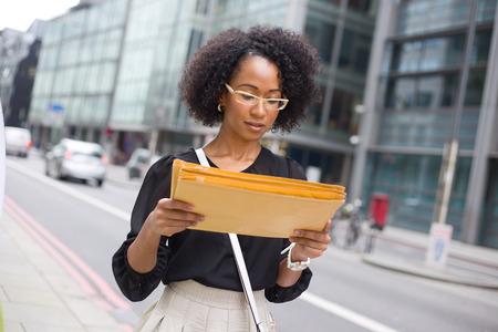 young office girl reading the address on envelopesの写真素材