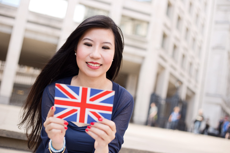 Japanese woman reading a post card with the union jackの写真素材
