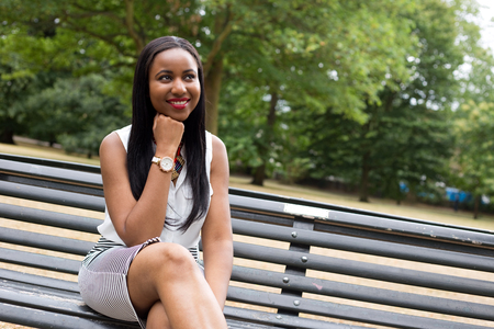 young woman sitting in the park thinkingの写真素材