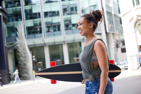 city girl in the street holding her longboardの写真素材