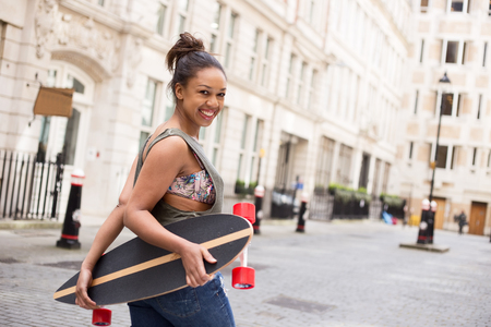 young woman holding her skateboardの写真素材