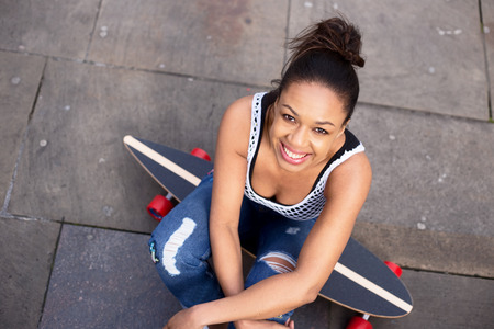 young woman sitting on her skateboardの写真素材