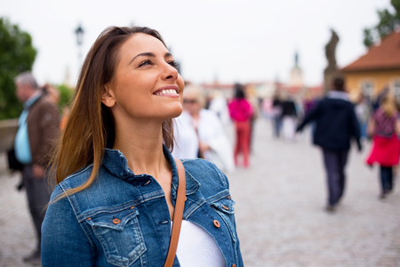 happy young woman smiling on charles bridge in Pragueの写真素材