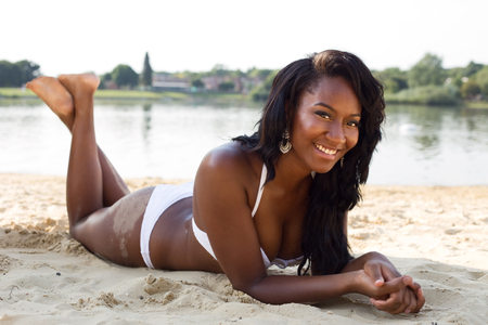 young woman lying on the beach in her bikiniの写真素材