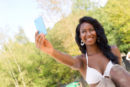 young woman at the beach taking a selfieの写真素材