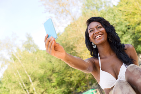 happy girl at the beach taking a selfieの写真素材