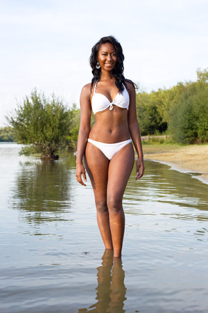 attractive young woman enjoying the lake in her bikiniの写真素材