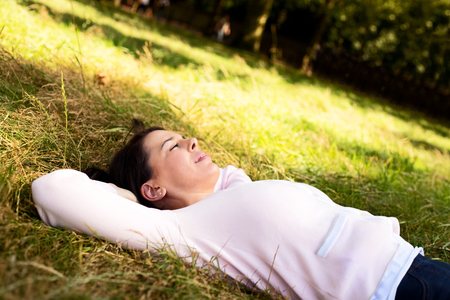 young woman lying in the park relaxingの写真素材