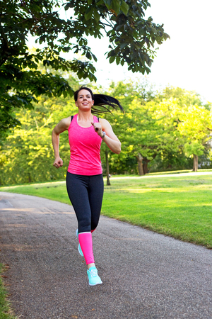 young woman running in the parkの写真素材