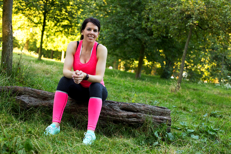 fitness girl sitting on a log having a restの写真素材