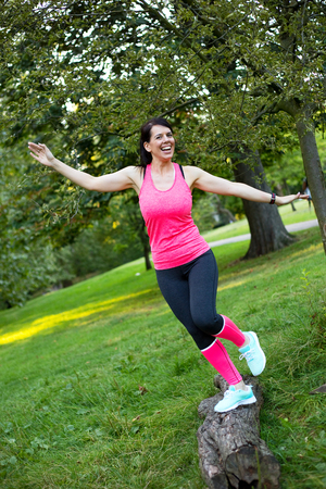 fitness girl having fun balancing on a logの写真素材