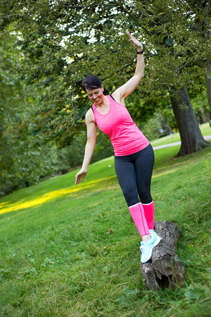 fitness girl having fun balancing on a logの写真素材