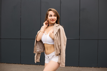 portrait of a young woman posing wearing hot pants, a crop top and her jacketの写真素材