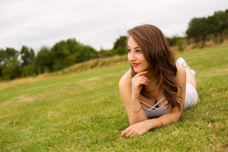 young woman lying on the grass in the parkの写真素材