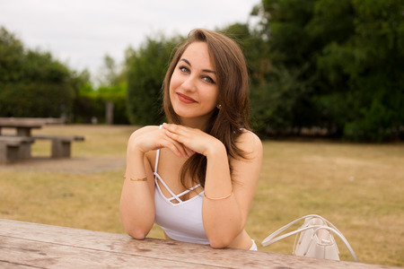 young woman enjoying her day sitting in the parkの写真素材