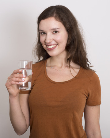 young woman holding a glass of waterの写真素材