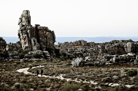 Two men hiking between the rocksの写真素材