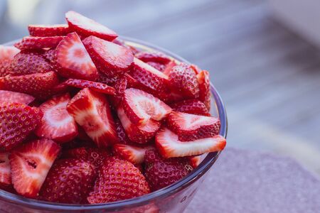 Fresh cut bowl of strawberries in a glass bowl with copyspaceの写真素材