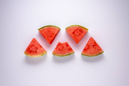 Five slices of water melon against a white background.の写真素材
