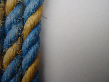 Close up of some blue and yellow rope on a white background